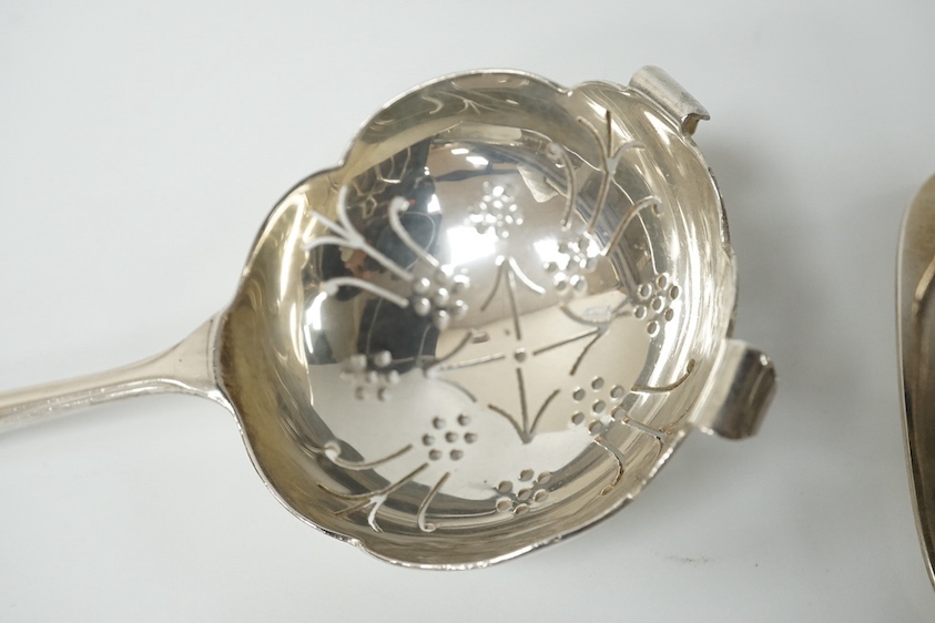 A pair of George V/VI silver five bar toast racks by Hukin & Heath, Birmingham, 1935/39, length 89mm, together with a silver tea strainer and stand, Sheffield, 1958, 9.1oz. Condition - fair to good